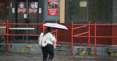 A woman walks through rain and flood waters, as the remnants of Tropical Storm Ophelia bring flooding across mid-Atlantic and Northeast, in the Brooklyn borough of New York City, U.S., Sept. 29, 2023. (Reuters Photo)