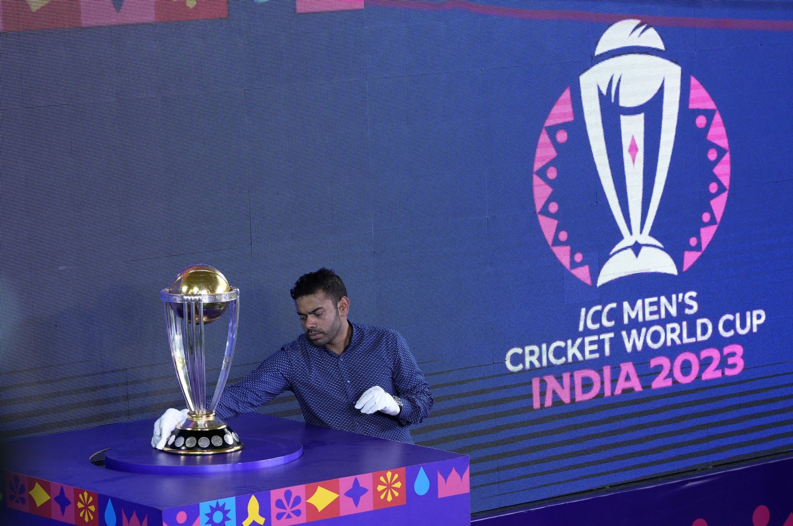 An official wipes the ICC Cricket World Cup trophy before its unveiling at the Eden Gardens, Kolkata, India, Sept. 8, 2023. (AP Photo)