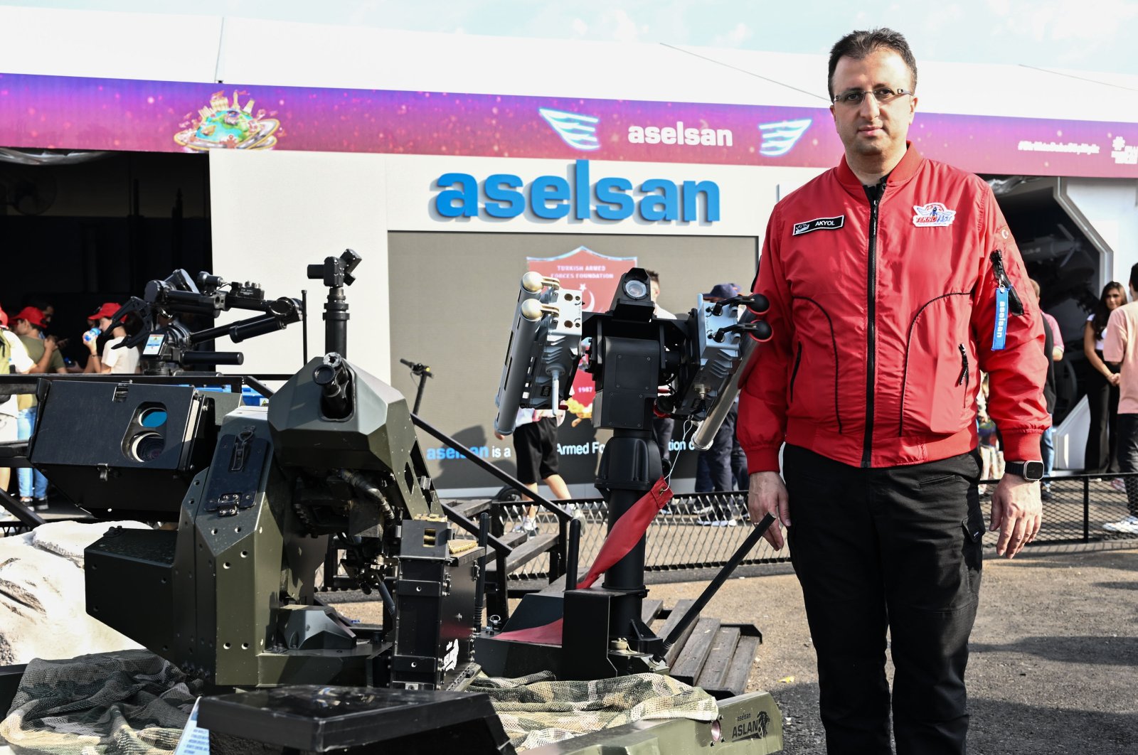 Ahmet Akyol, general manager of Aselsan, poses next to the unmanned ground vehicle Aslan exhibited at Teknofest in Izmir, western Türkiye, Sept. 29, 2023. (AA Photo)