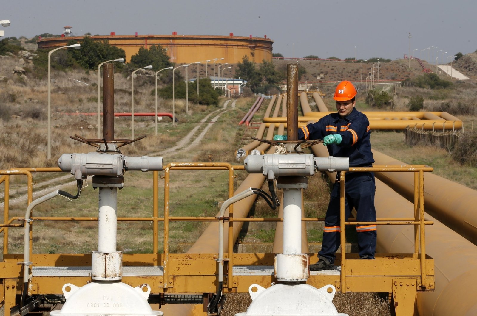 A worker checks valve gears of pipes linked to oil tanks at the Mediterranean port of Ceyhan, southern Türkiye, Feb. 19, 2014. (Reuters Photo)