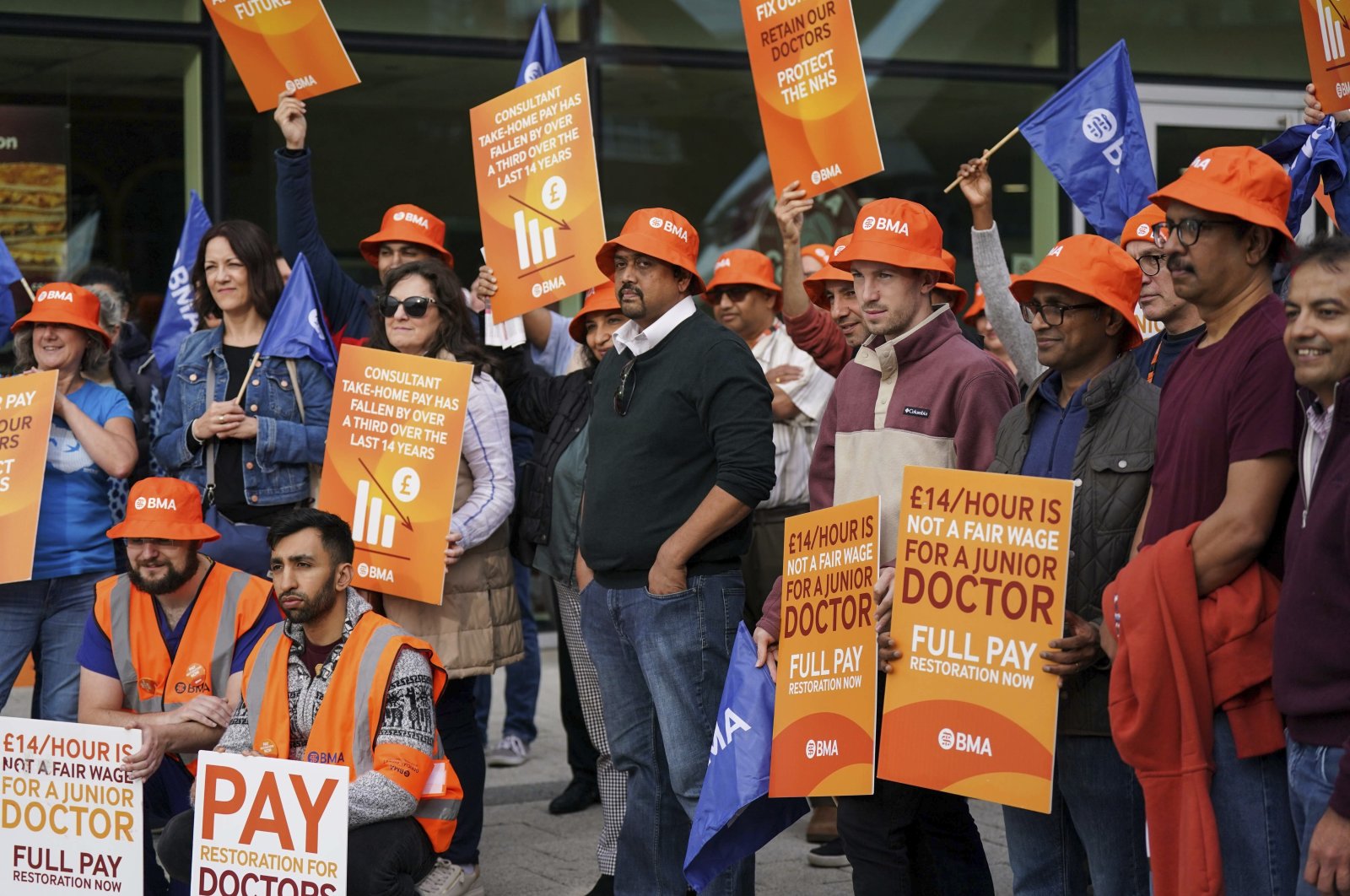 Junior doctors and medical consultant members of the British Medical Association (BMA) carry placards on the picket line outside Queen Elizabeth Hospital, on the first day of a three-day joint walkout amid their dispute with the government over pay, in Birmingham, U.K., Oct. 2, 2023. (AP Photo)