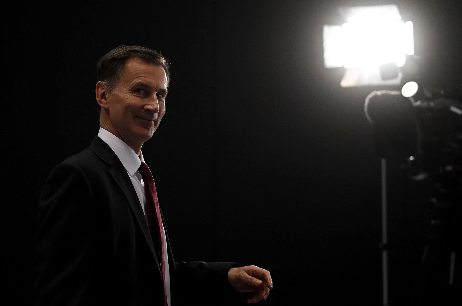 Britain&#039;s Treasury chief Jeremy Hunt smiles during a tour of TV studios at the annual Conservative Party Conference in Manchester, northern England, Oct. 2, 2023. (AFP Photo))