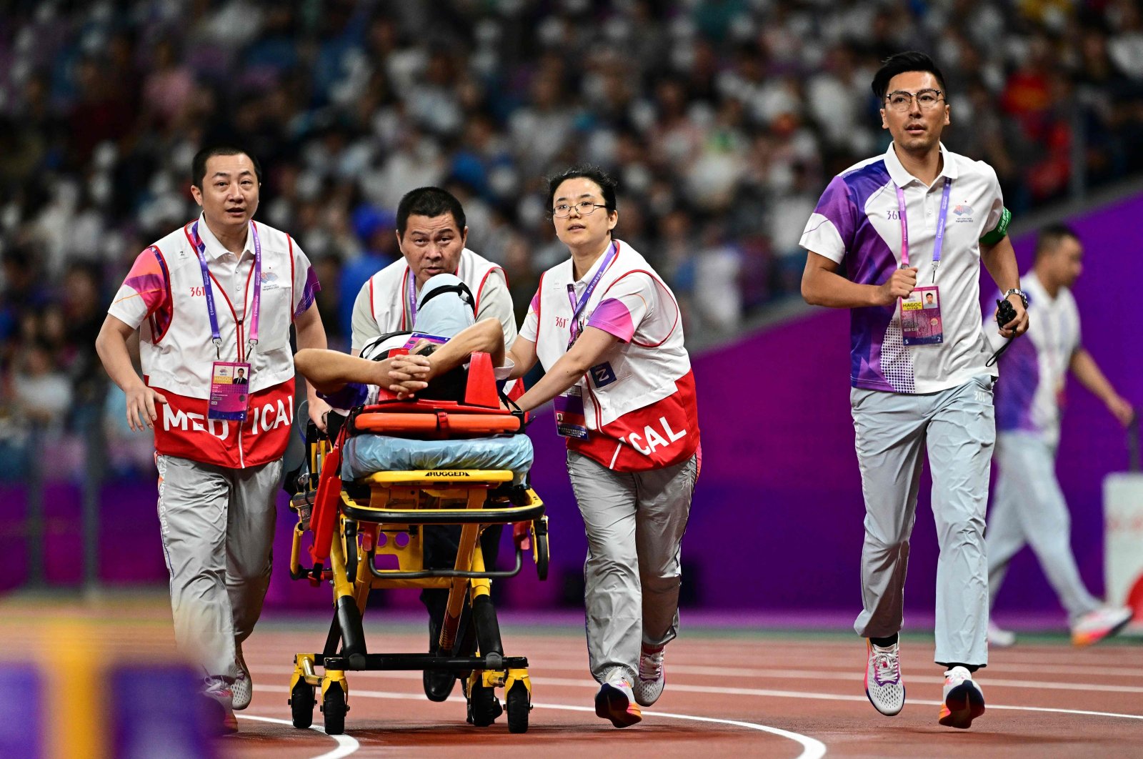 An official leaves the track and field on a stretcher after his leg was injured by a stray hammer during the men&#039;s hammer throw final athletics event during the 2022 Asian Games, Hangzhou, China, Sept. 30, 2023. (AFP Photo)