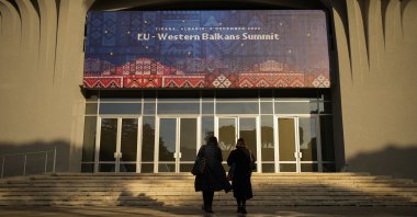 People walk outside the venue of the EU Western Balkans Summit, in Tirana, Albania, Dec. 5, 2022. (AP Photo)
