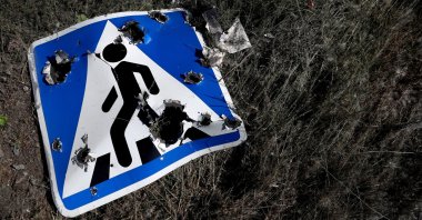 A road sign damaged by cluster munition is seen on the outskirts of Kharkiv, Ukraine, June 10, 2022. (Reuters Photo)
