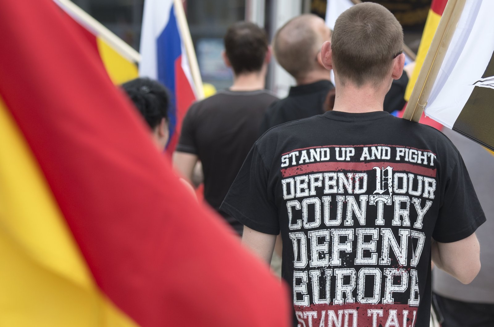 People stand behind a German flag during a rally of a right-wing group, Erfurt, Germany, June 4, 2016. (AP Photo)