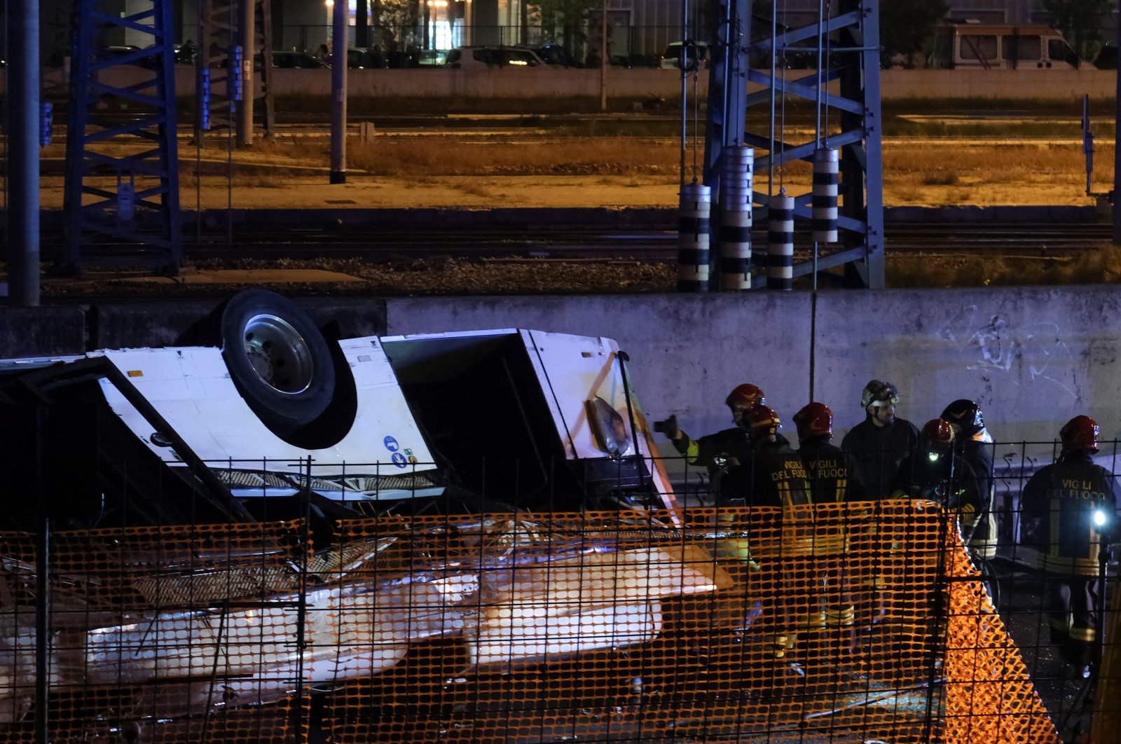 Firefighters work near a coach after it crashed off an overpass in Mestre, Italy, Oct. 3, 2023. (Reuters Photo)