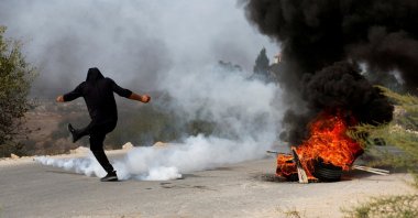A Palestinian protestor kicks a tear-gas canister during clashes with the Israeli forces, near Tulkarm, in the Israeli-occupied West Bank, Oct. 5, 2023. (Reuters Photo)