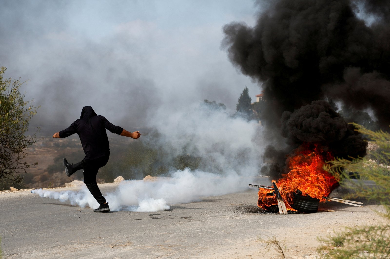 A Palestinian protestor kicks a tear-gas canister during clashes with the Israeli forces, near Tulkarm, in the Israeli-occupied West Bank, Oct. 5, 2023. (Reuters Photo)