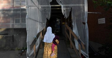 A girl with a child enters a residential building of Mjolnerparken housing estate in Copenhagen, Denmark, Aug. 28, 2023. (AFP Photo)