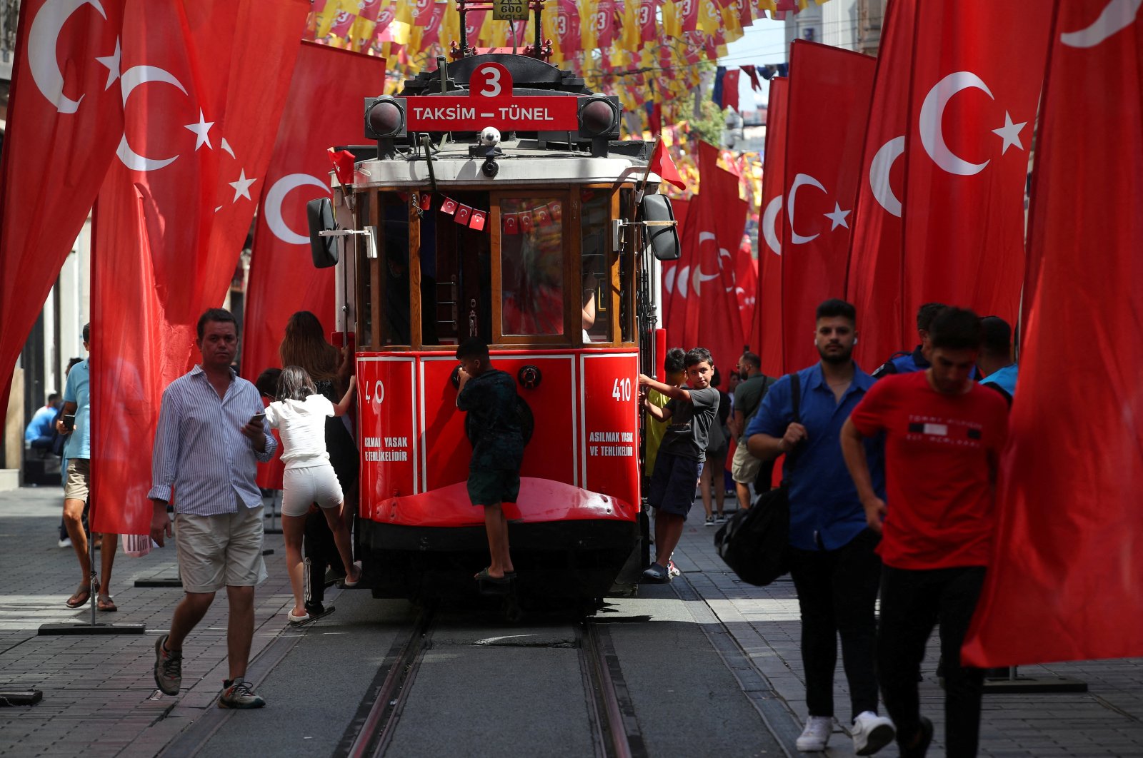 People stroll at the main shopping and pedestrian street of Istiklal which is decorated with Turkish flags to mark Victory Day, Istanbul, Türkiye, Aug. 30, 2023. (Reuters Photo)