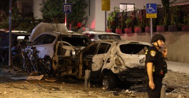 A member of the Israeli security forces stands along a debris-strewn street in Tel Aviv, after it was hit by a rocket fired by Hamas from the Gaza Strip on Oct. 7, 2023. (AFP Photo)