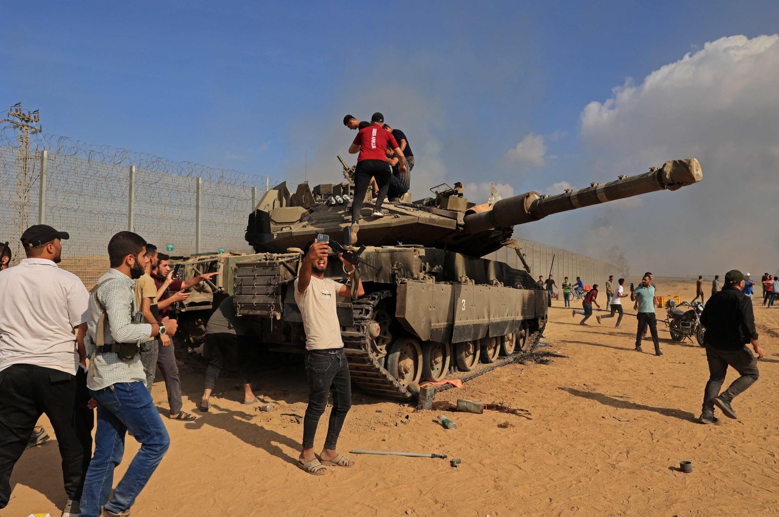 Palestinians take control of an Israeli tank after crossing the border fence with Israel from Khan Yunis in the southern Gaza Strip on Oct. 7, 2023. (AFP Photo)