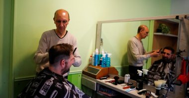 Barber Ruben Galante, 67, cuts the hair of customer Luciano Munoz, 46, at his shop, in Buenos Aires, Argentina, Sept. 22, 2023. (Reuters Photo)