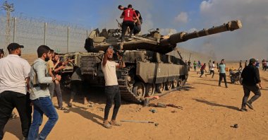 Palestinians take control of an Israeli tank after crossing the border fence with Israel from Khan Yunis in the southern Gaza Strip, Palestine, Oct. 7, 2023. (AFP Photo)