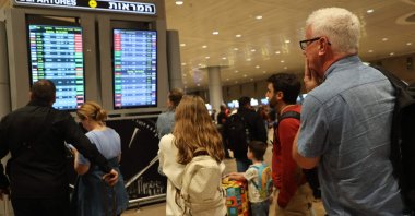 Passengers look at a departure board at Ben Gurion Airport as flights are canceled because of Hamas' surprise attacks, in Tel Aviv, Israel, Oct. 7, 2023. (AFP Photo)