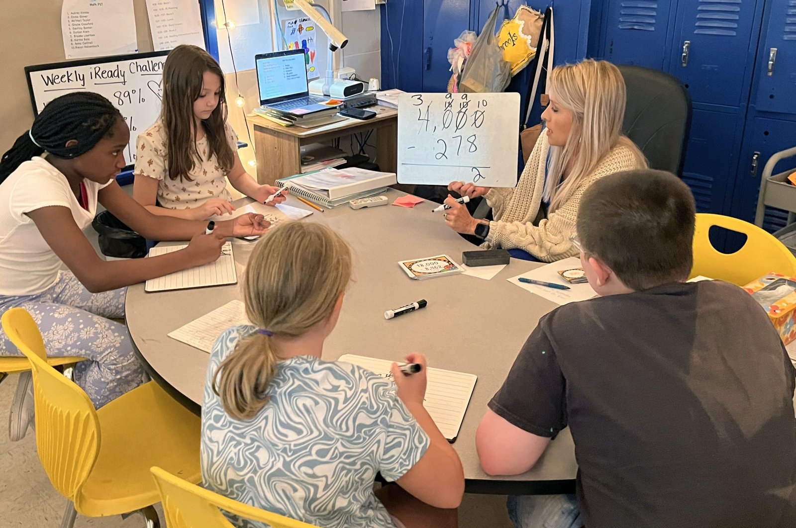 Piedmont Elementary School math teacher Cassie Holbrooks helps a small group of fourth-grade students with a three-digit subtraction problem in Piedmont, Alabama, U.S., Aug. 31, 2023. (AP Photo)