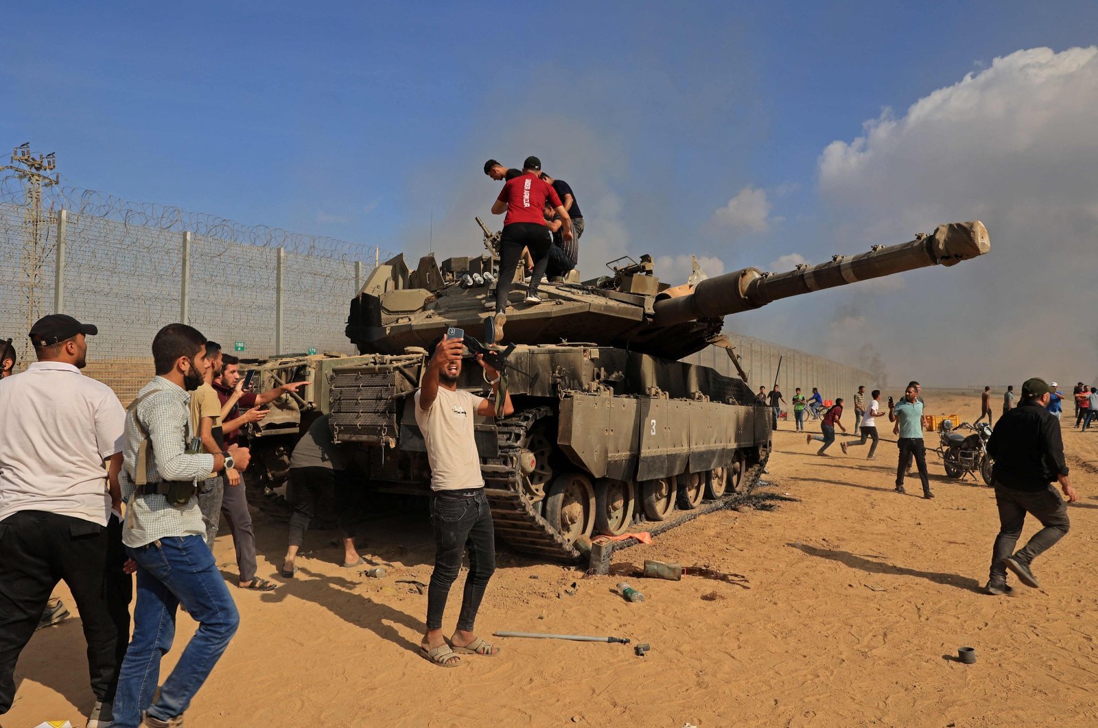 Palestinians take control of an Israeli tank after crossing the border fence with Israel from Khan Yunis in the southern Gaza Strip, Palestine, Oct. 7, 2023. (AFP Photo)