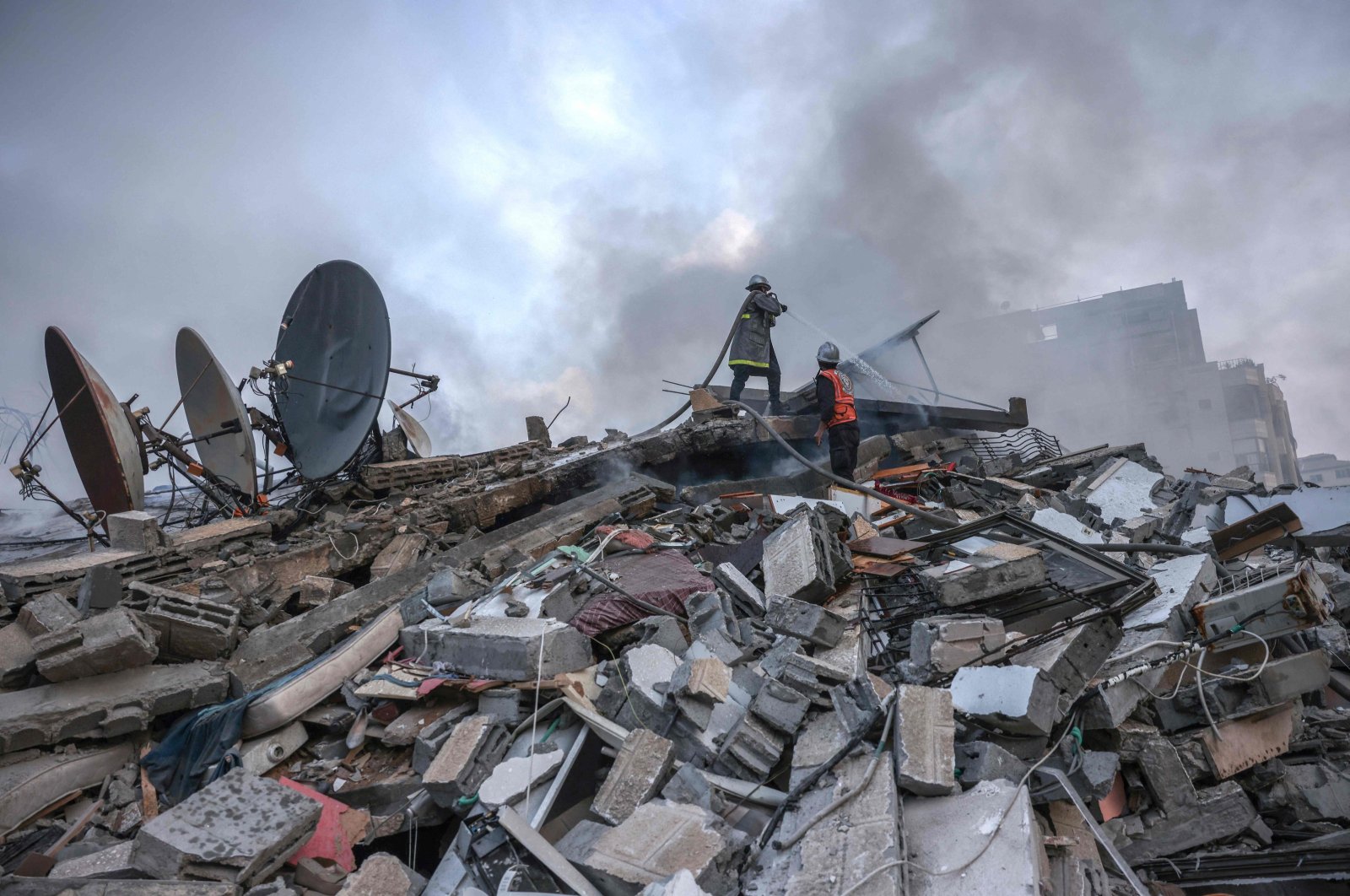 Palestinian firemen extinguish a fire at a residential building destroyed by Israeli airstrikes, Gaza City, Palestine, Oct. 8, 2023. (AFP Photo)