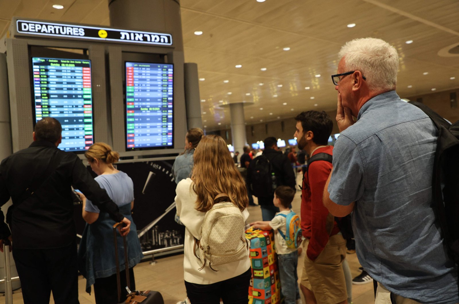 Passengers look at a departure board at Ben Gurion Airport as flights are canceled because of Hamas&#039; surprise attacks, in Tel Aviv, Israel, Oct. 7, 2023. (AFP Photo)