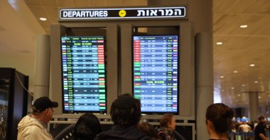 Passengers look at a departure board at Ben Gurion Airport near Tel Aviv, Israel, on Oct. 7, 2023. (AFP Photo)