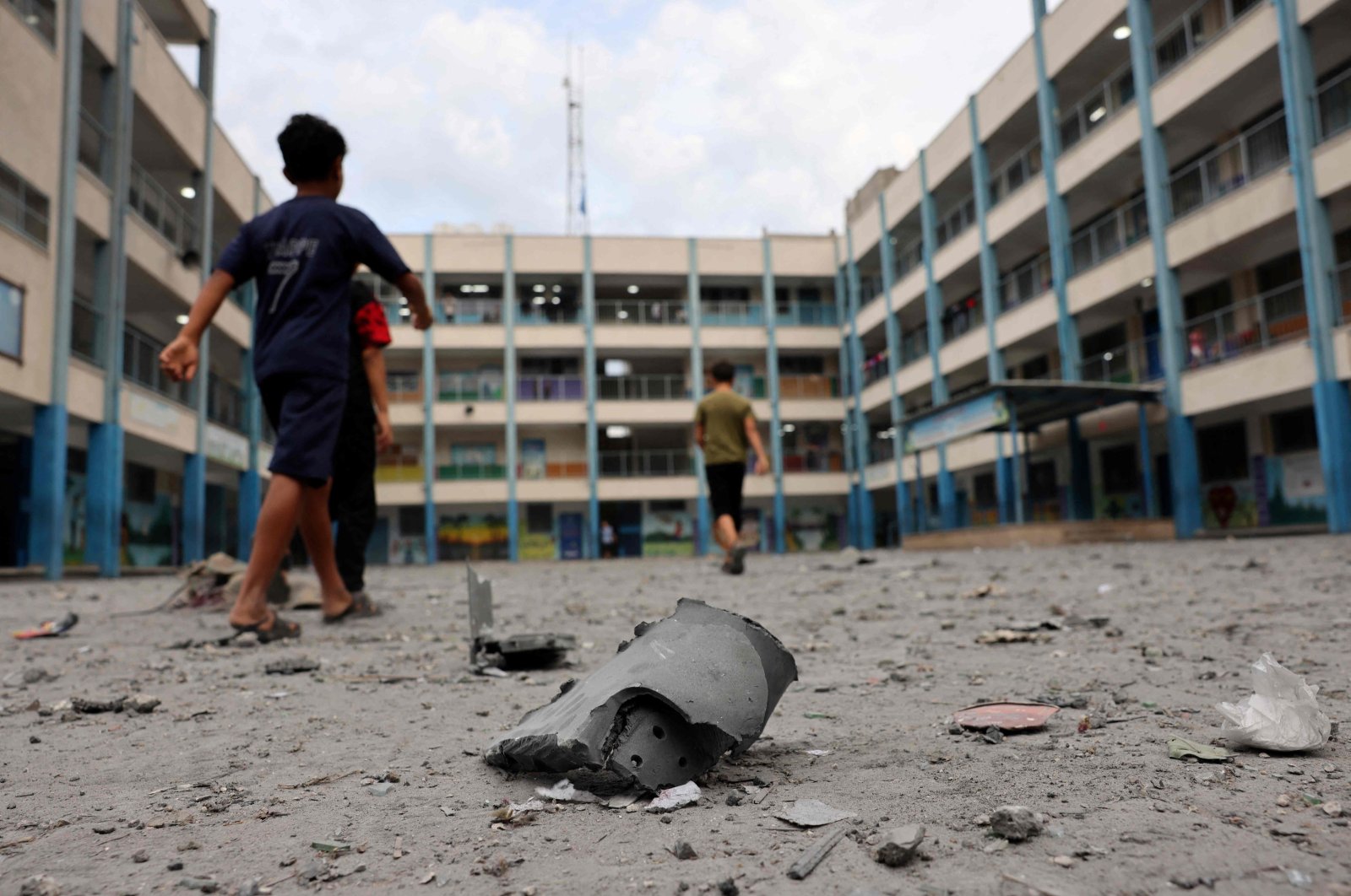 Palestinian children walk past debris in the courtyard of a school run by the U.N. agency for Palestinian refugees (UNRWA) following Israeli airstrikes on Gaza City, Palestine, Oct. 9, 2023. (AFP Photo)