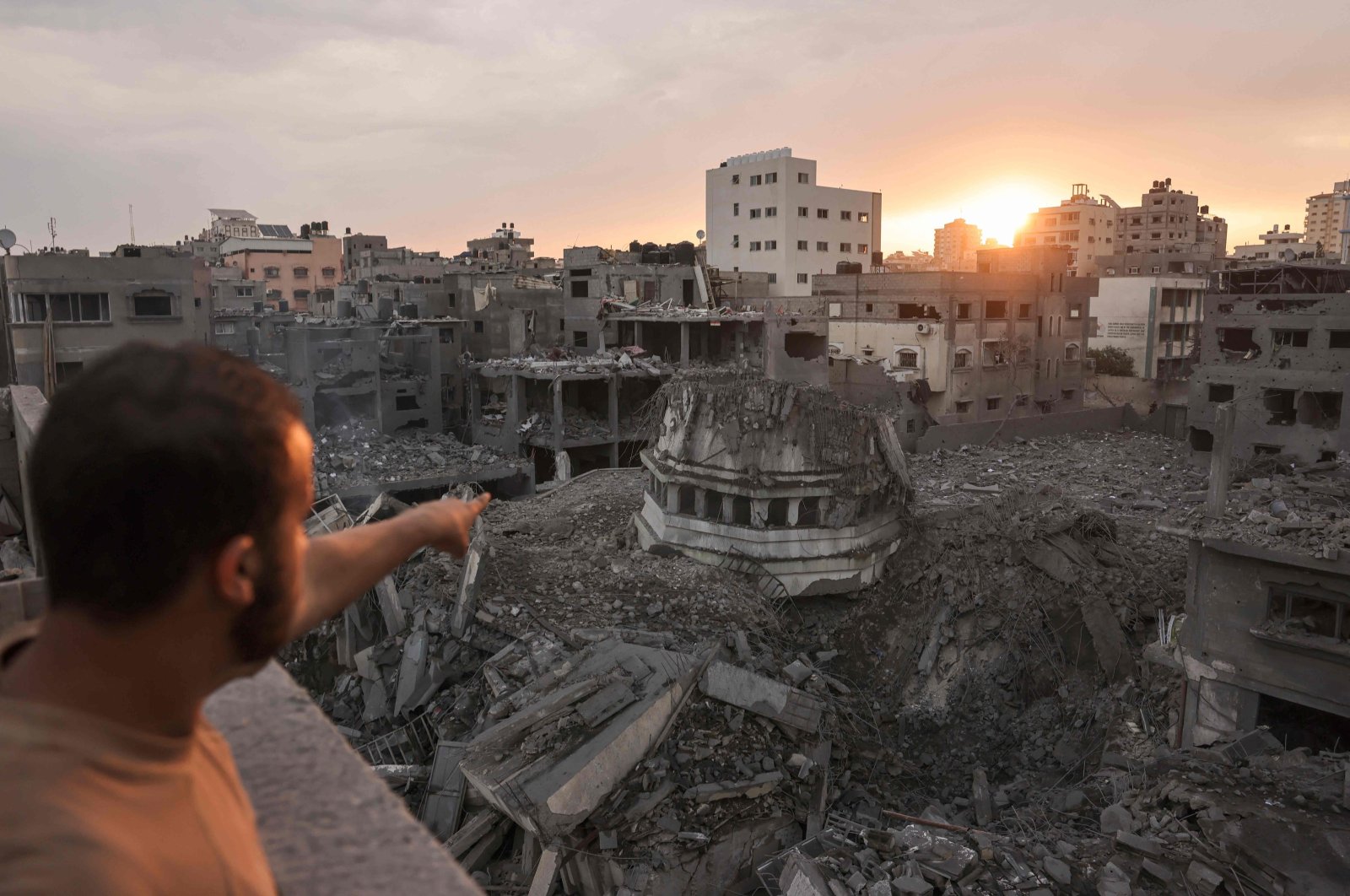 A Palestinian points to the Ahmed Yassin mosque, which was leveled by Israeli airstrikes, in Gaza City, Oct. 9, 2023. (AFP Photo)