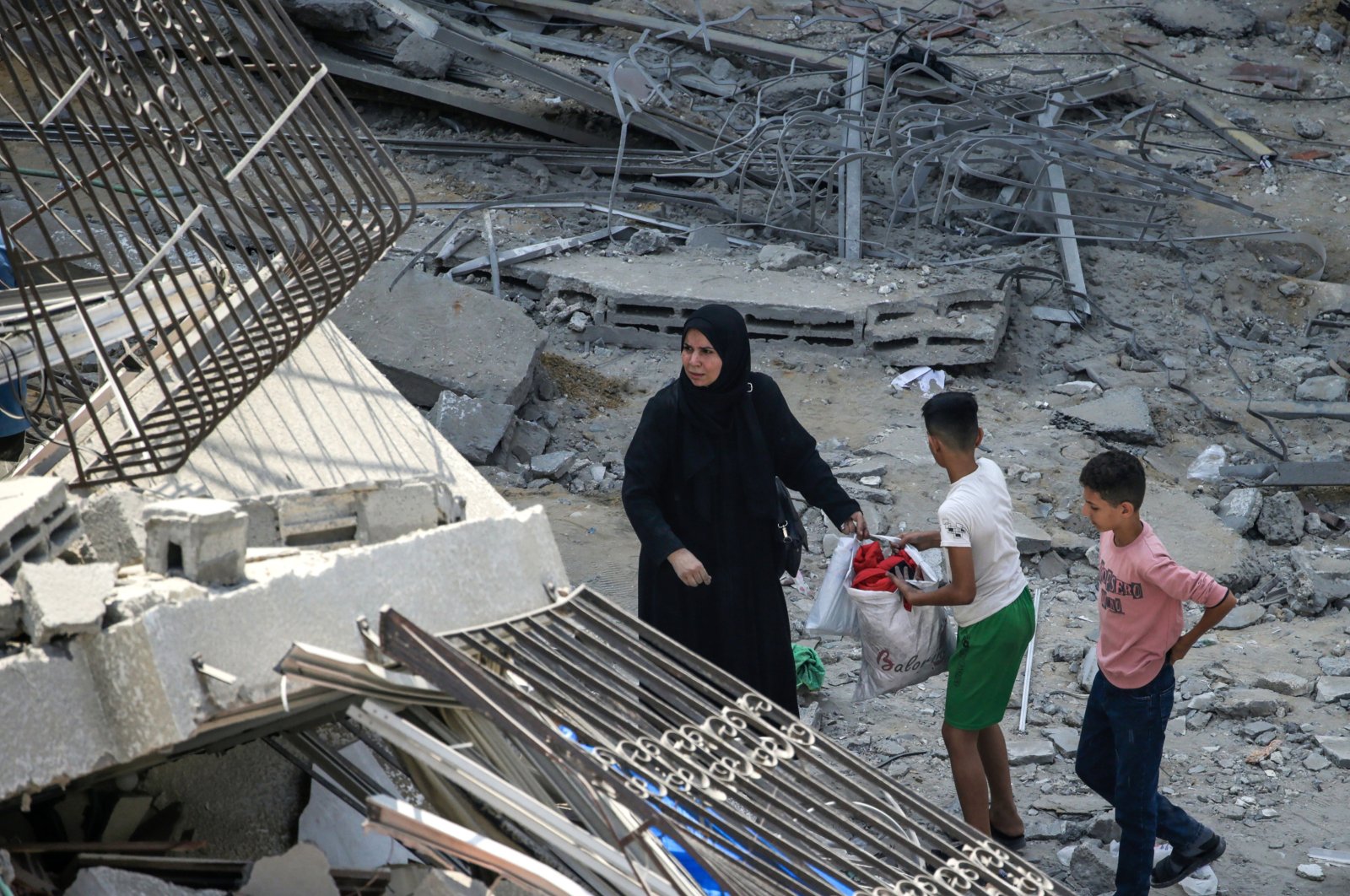 A Palestinian mother and her children inspect the rubble of their apartment at the destroyed Al-Aklouk Tower following Israeli airstrikes, in Gaza City, Oct. 8, 2023. (EPA Photo)