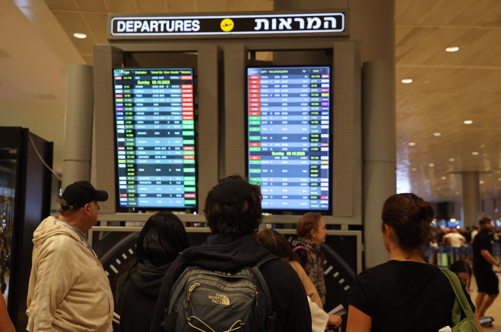Passengers look at a departure board at Ben Gurion Airport near Tel Aviv, Israel, on Oct. 7, 2023. (AFP Photo)