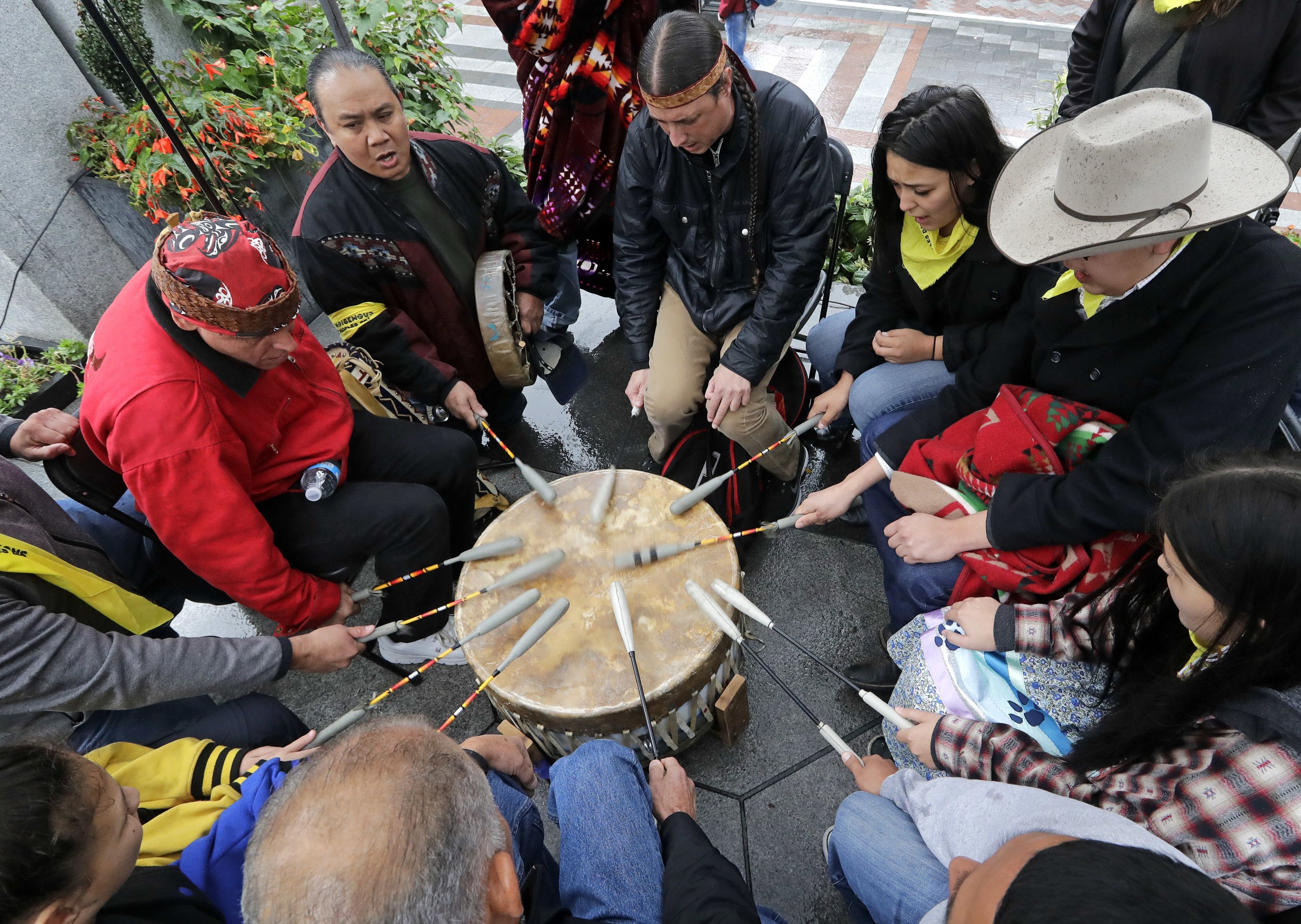 Native Americans and First Nations people join in on a drum circle during an Indigenous Peoples Day blessing and rally before a march, Seattle, U.S., Oct. 9, 2018. (AP Photo)