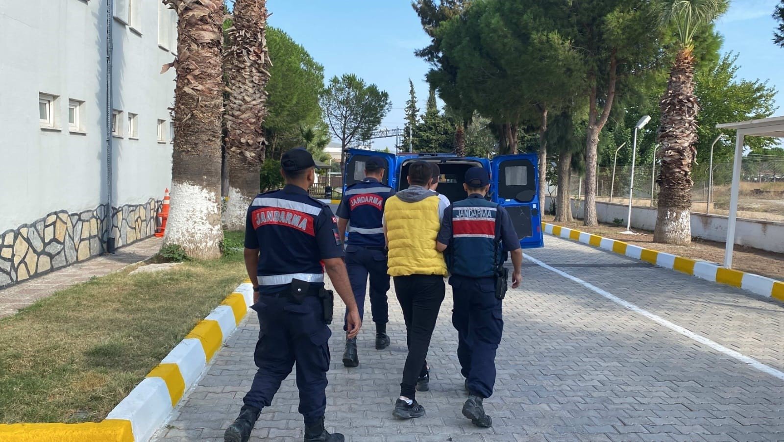 Gendarmerie troops escort a suspect captured in an operation against migrant smugglers, in Izmir, western Türkiye, Oct.9, 2023. (IHA Photo)