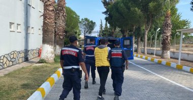 Gendarmerie troops escort a suspect captured in an operation against migrant smugglers, in Izmir, western Türkiye, Oct.9, 2023. (IHA Photo)