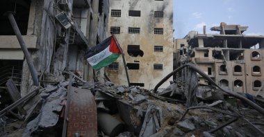 A Palestinian flag is seen on the rubble of a building destroyed in Israeli airstrikes in Gaza City's Rimal district, Palestine, Oct. 10, 2023. (AFP Photo)