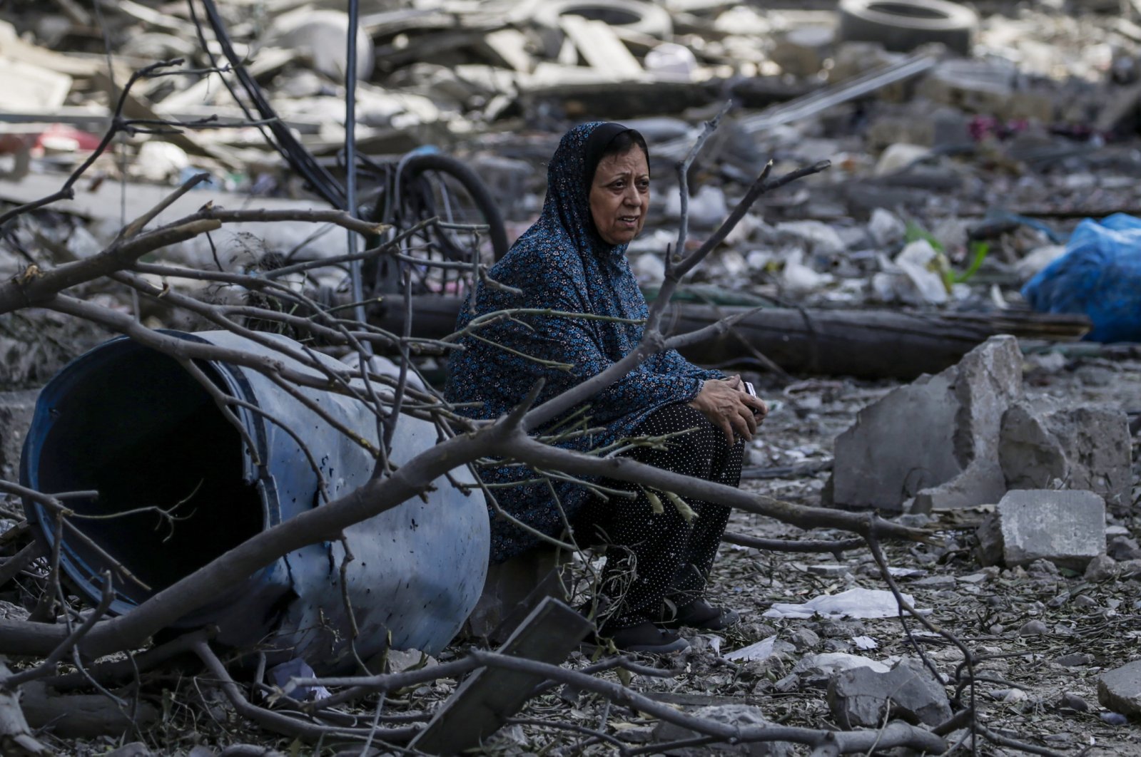 A Palestinian woman sits among the rubble in the destroyed Al-Ramal neighborhood following an Israeli air strike in Gaza City, Oct. 10, 2023. (EPA Photo)