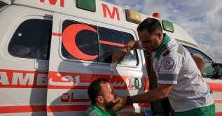 A Palestinian Red Crescent medic pours water on a protester's face during a demonstration along the border, east of Gaza City, to mark Israel's withdrawal from the Gaza Strip in 2005, Sept. 13, 2023. (AFP File Photo)