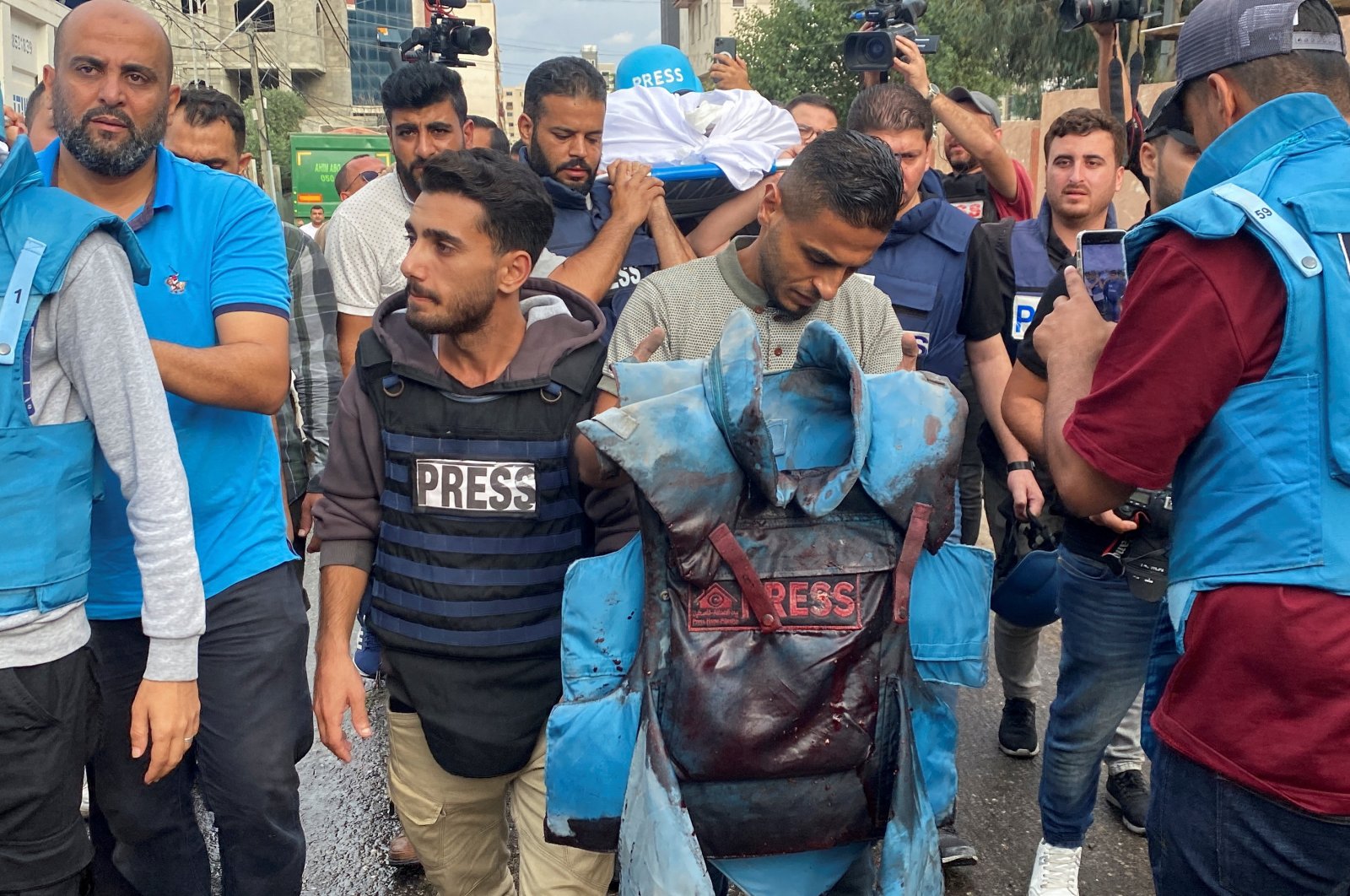 A colleague carries the blood-stained flak jacket belonging to Palestinian journalist Muhammed Subh, who was killed along with two other journalists in an Israeli missile strike in Gaza City, Palestine, Oct. 10, 2023. (Reuters Photo)