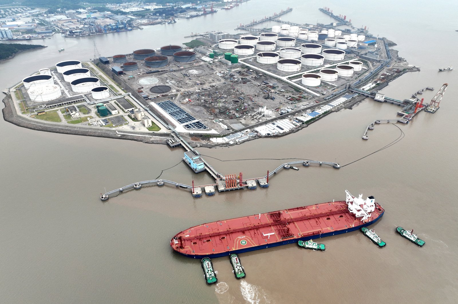 An aerial view shows tugboats helping a crude oil tanker to berth at an oil terminal, off Waidiao Island in Zhoushan, Zhejiang province, China, July 18, 2022. (Reuters Photo)