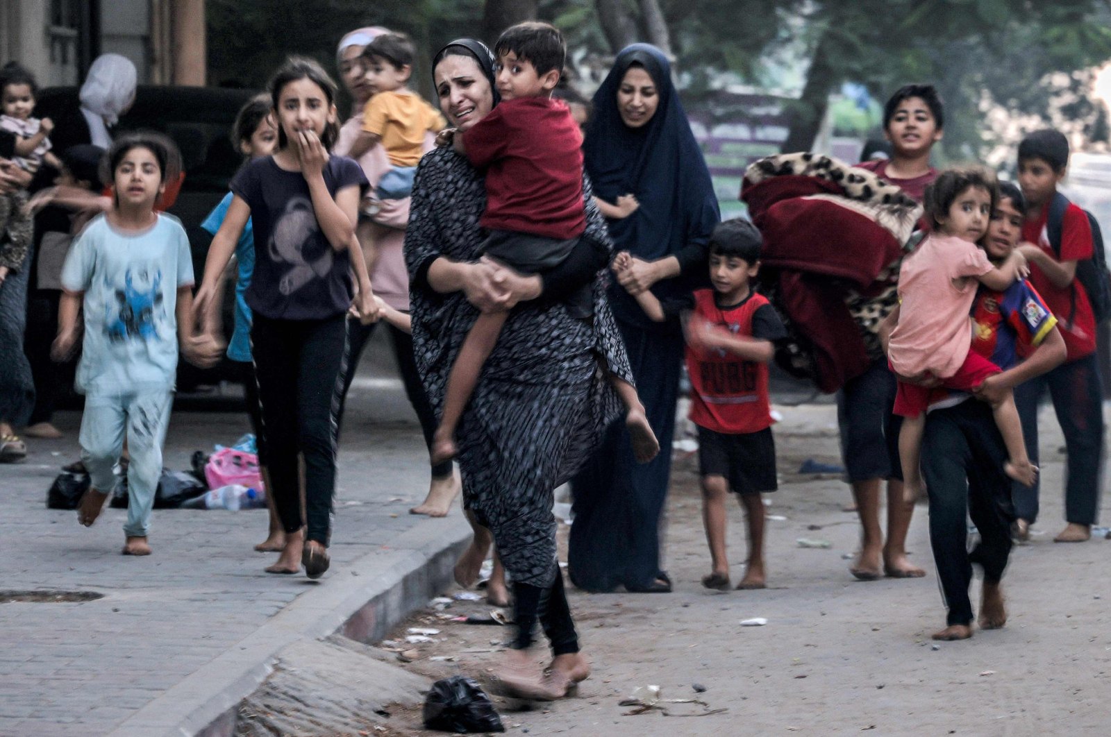 Palestinian women with their children flee from their homes following Israeli airstrikes on Gaza City, Palestine, Oct. 11, 2023. (AFP Photo)