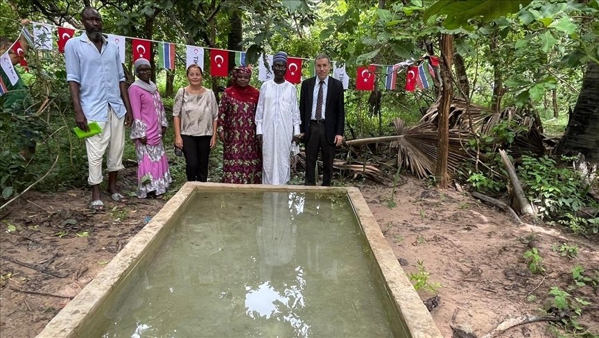 Turkish Cooperation and Coordination Agency (TIKA) members and Gambian officials stand in front of a pond at the Monkey Park, Serrekunda, Gambia, Oct. 11, 2023. (AA Photo)