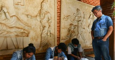 Heritage conservationist and Nepal Vocational Academy founder Rabindra Puri (R) watches artisans sculpt stone structures at the academy in Bhaktapur on the outskirts of Kathmandu, Nepal, July 14, 2023. (AFP Photo)