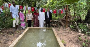 Turkish Cooperation and Coordination Agency (TIKA) members and Gambian officials stand in front of a pond at the Monkey Park, Serrekunda, Gambia, Oct. 11, 2023. (AA Photo)