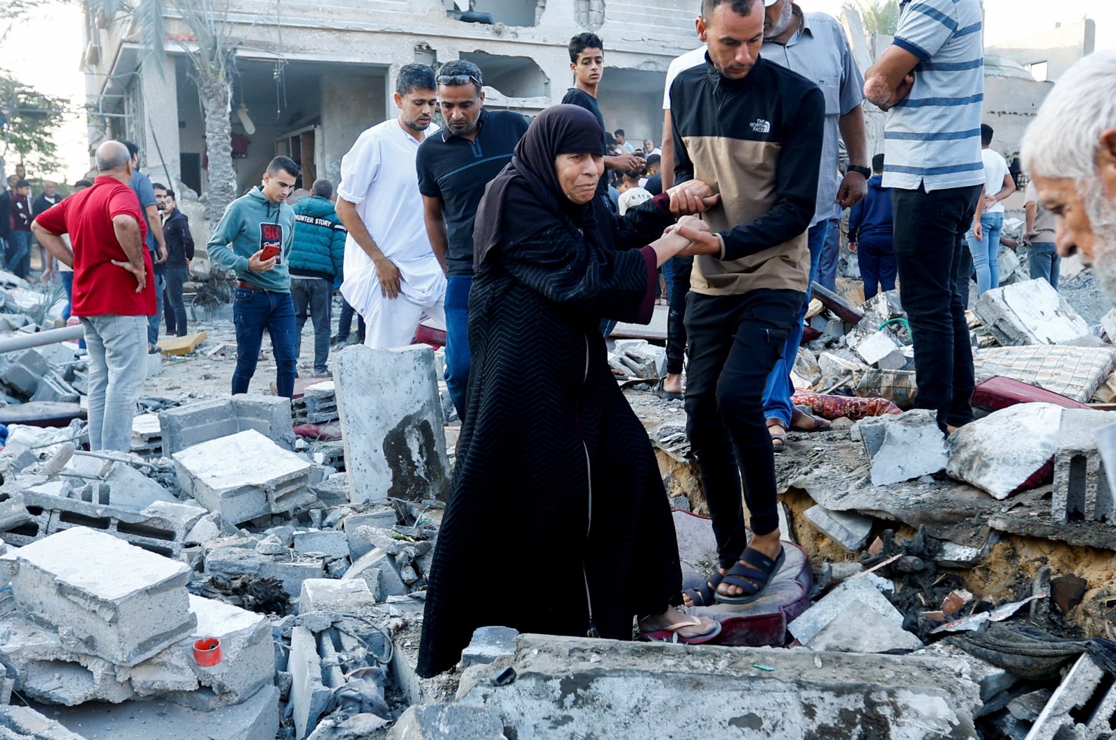 People walk on rubble in the aftermath of a strike amid the conflict with Israel in Khan Younis, in the southern Gaza Strip, Palestine, Oct.12, 2023. (Reuters Photo)