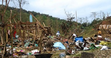 People look through debris in the aftermath of a military strike on a camp for displaced people, Laiza, Myanmar, Oct. 11, 2023. (AFP Photo)