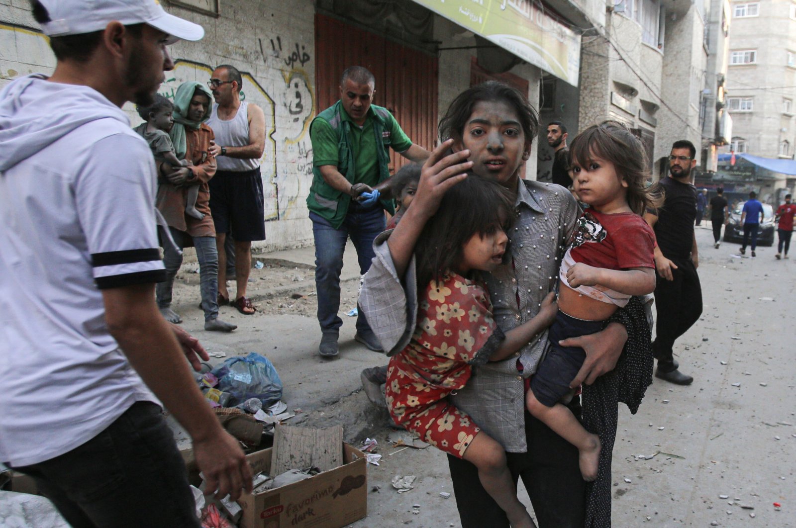 A Palestinian girl holds two children as she stands on a street, Gaza City, Palestine, Oct. 12, 2023. (AFP Photo)