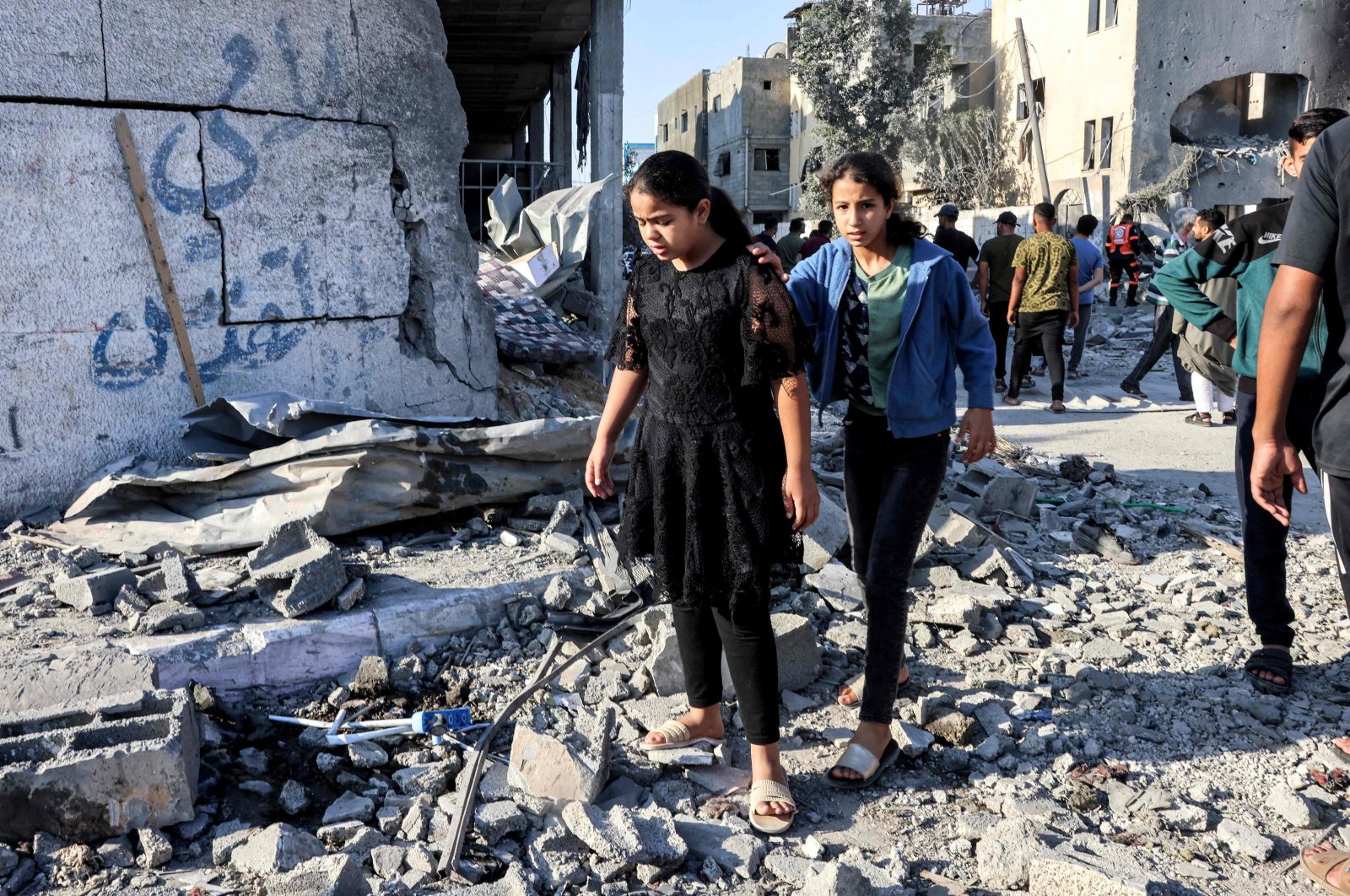 Palestinian girls walk through rubble in the aftermath of an Israeli air strike in Gaza, Palestine, October 13, 2023. (AFP Photo)
