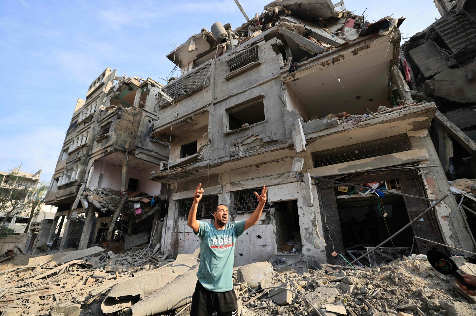 A Palestinian man reacts as he stands amid the destruction in the aftermath of Israeli bombardment in al-Karama district in Gaza City on Oct.11, 2023. (AFP Photo)