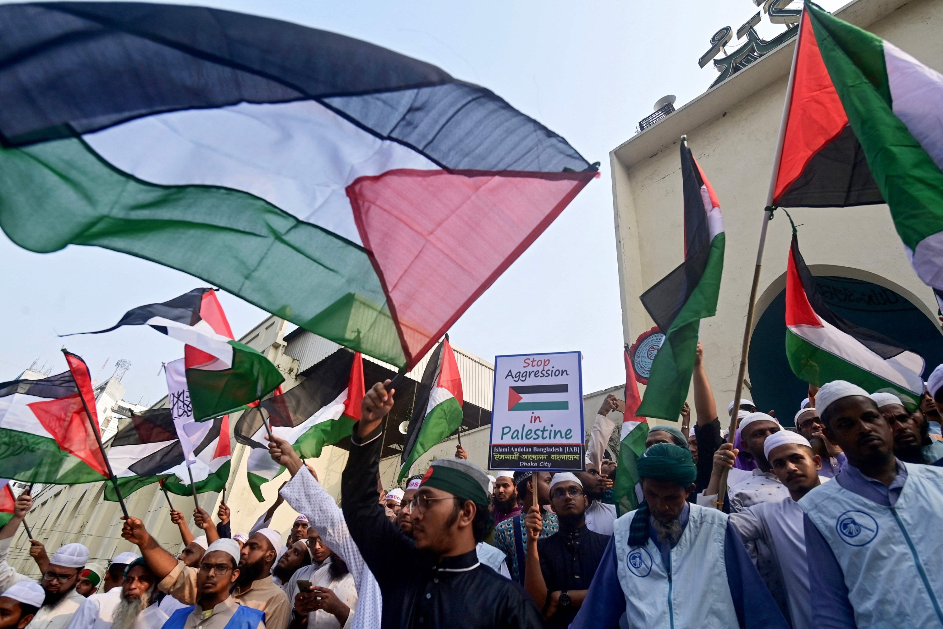 TOPSHOT - Protestors wave the national flag of Palestine as they shout slogans during an anti-Israel demonstration in Dhaka on October 10, 2023. Israel said it had largely secured the Gaza border and was evacuating nearby towns where the bodies of 1,500 Hamas militants had been recovered by October 10, after days of gruelling battles outside the Palestinian enclave. (Photo by Munir uz ZAMAN / AFP)