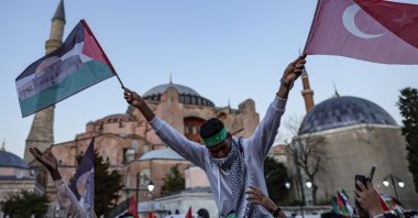 A pro-Palestine protester holds Turkish and Palestine flags in front of the Hagia Sophia Grand Mosque, Istanbul, Türkiye, Oct. 14, 2023. (EPA Photo)