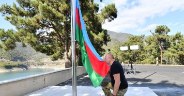 Azerbaijani President Ilham Aliyev kisses the flag before raising it near Sarsang Reservoir, Karabakh, Azerbaijan, Oct. 15, 2023. (AA Photo)