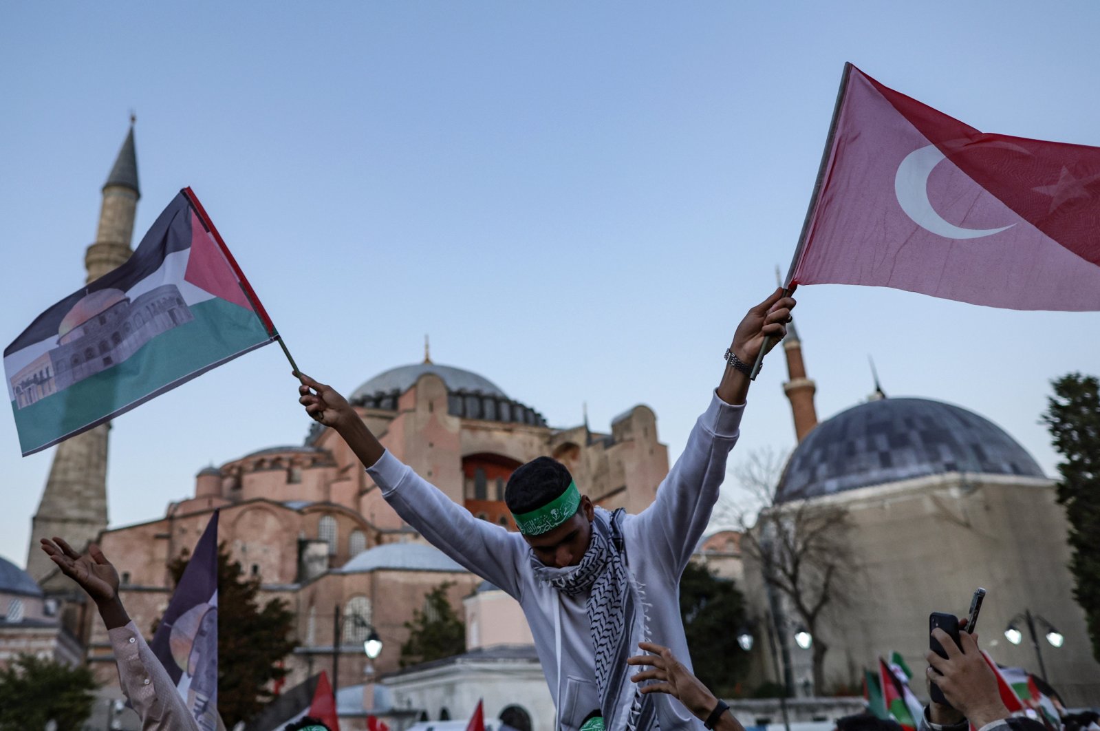 A pro-Palestine protester holds Turkish and Palestine flags in front of the Hagia Sophia Grand Mosque, Istanbul, Türkiye, Oct. 14, 2023. (EPA Photo)